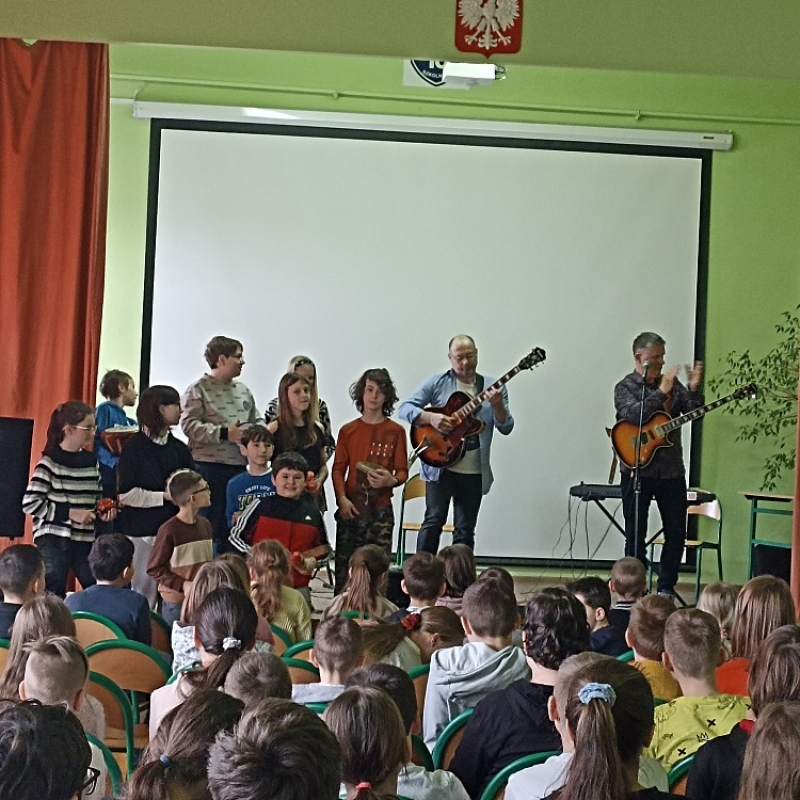 Uczniowie na scenie wraz z Prowadzącymi w wykonaniu wspólnego utworu