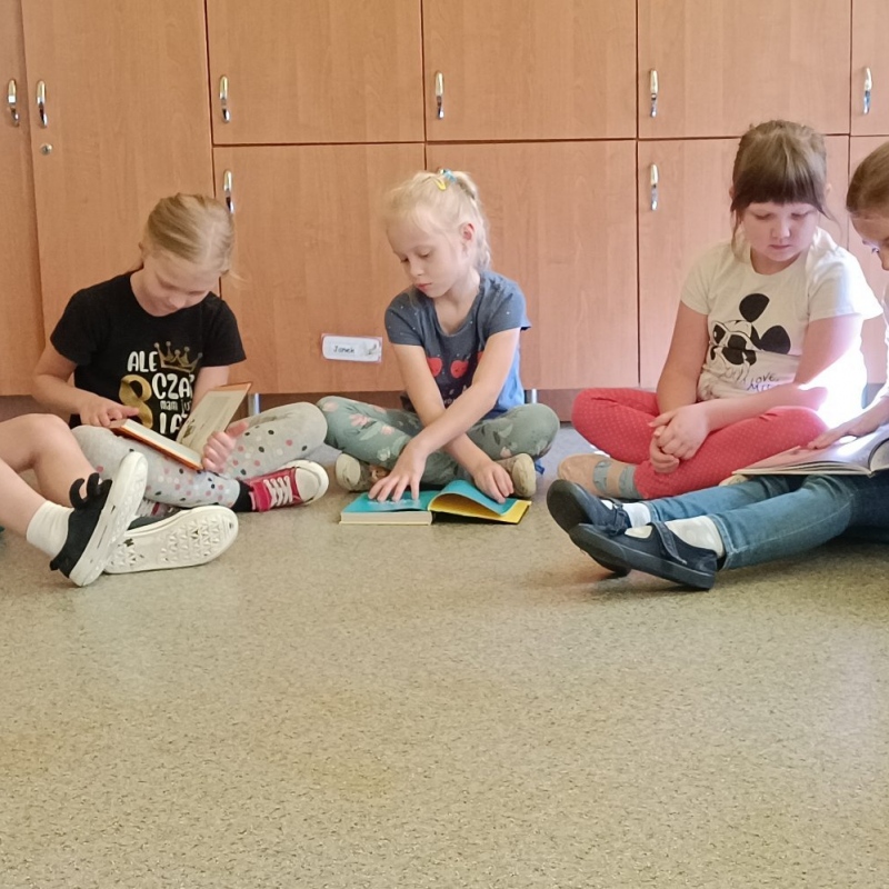 Uczniowie pierwszej klasy oglądają książki