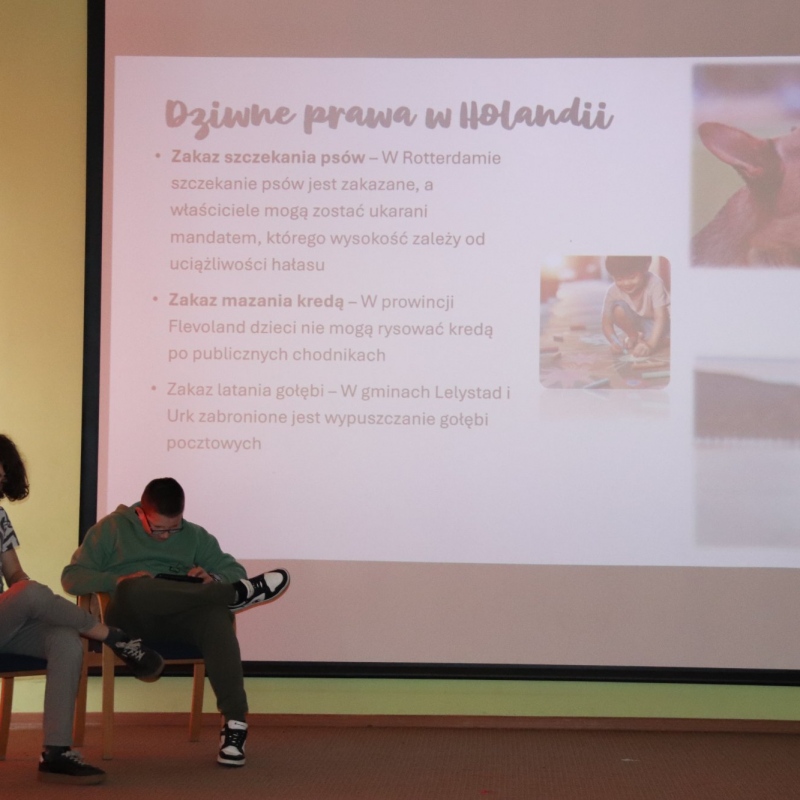Dwóch uczniów siedzi na scenie w tle slajd dziwne prawa w Holandii
