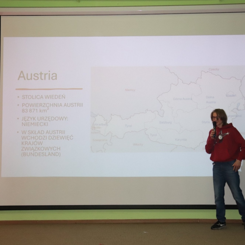 Dwoje uczniów na scenie w tle informacje o Austrii