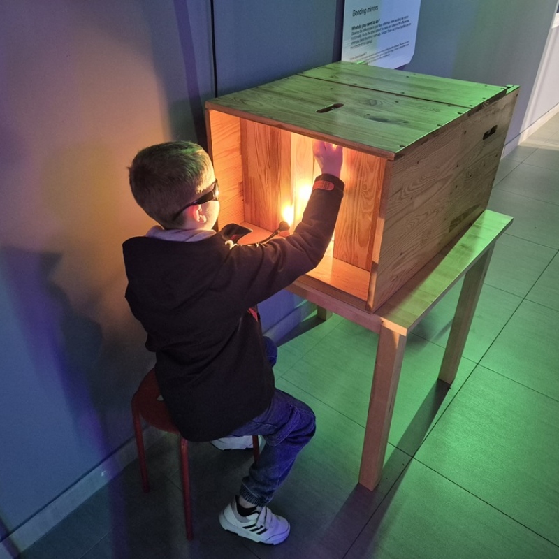 Uczeń ogląda eksponat na wystawie "Gdzie wzrok nie sięga"