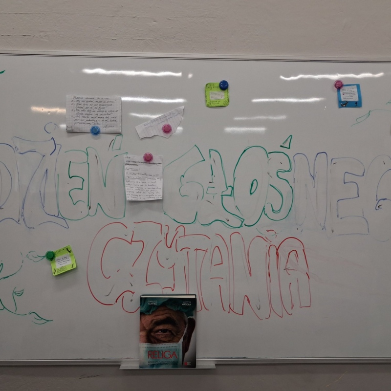Napis na tablicy dzień głośnego czytania z książką