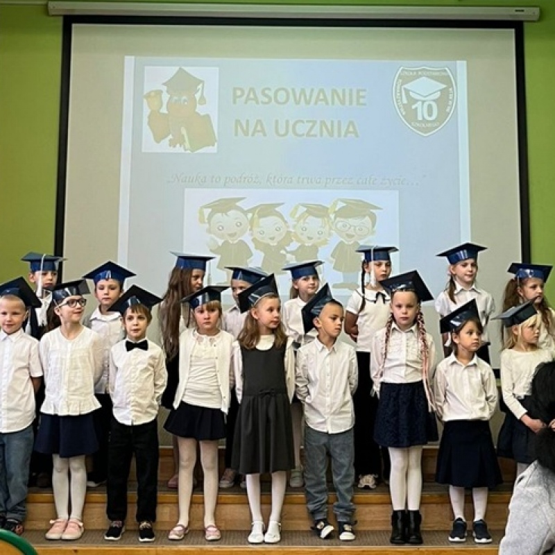 Uczniowie w biretach na podwyższeniu