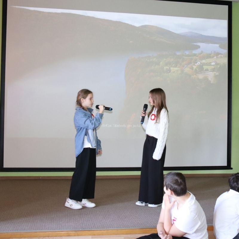 Dwie uczennice recytują na scenie