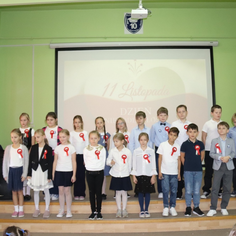 Uczniowie klasy 3 na scenie na tle wyświetlanego napisu 11 listopada
