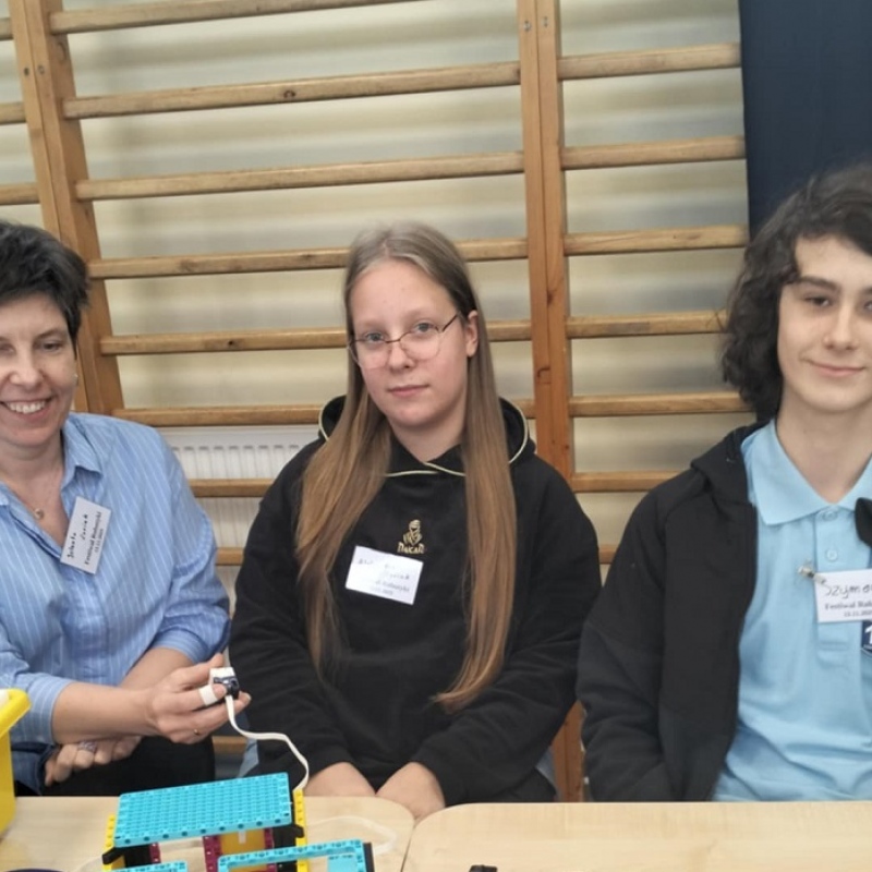 nauczyciel z uczniami testuje działanie konstrukcji z lego