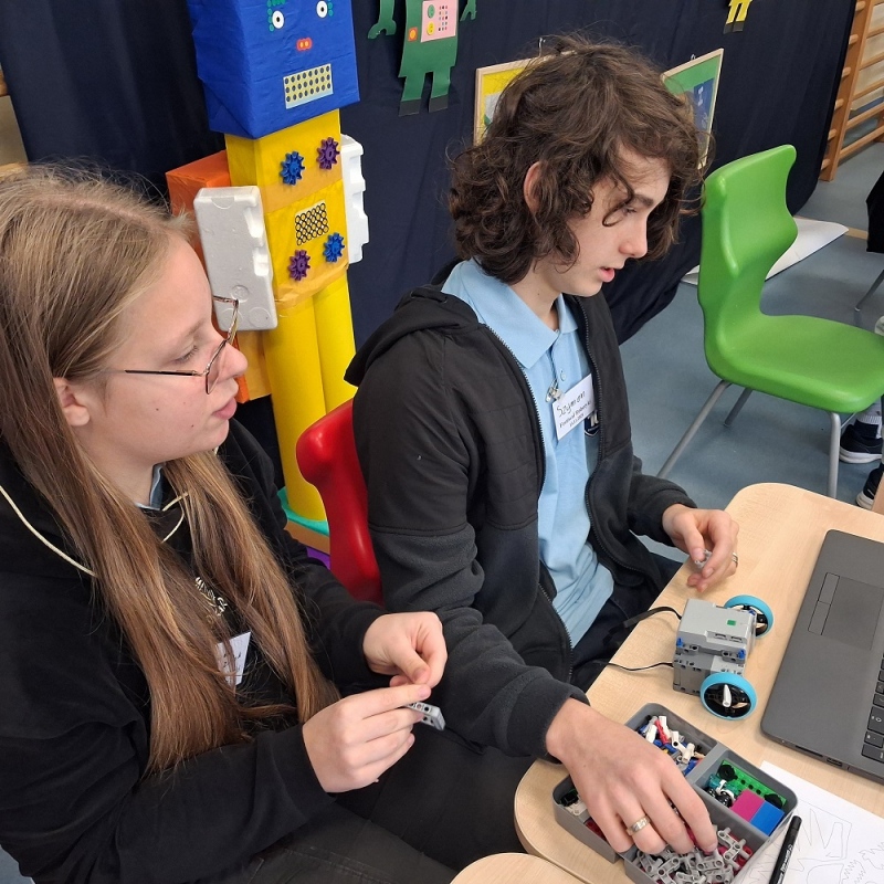 uczniowie budują z instrukcji pojazd z klocków lego