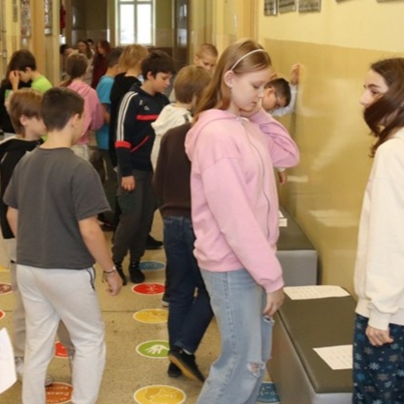 Uczniowie klasy 5 w trakcie wykonywania zadań w grupach i przechodzenia pomiędzy stacjami