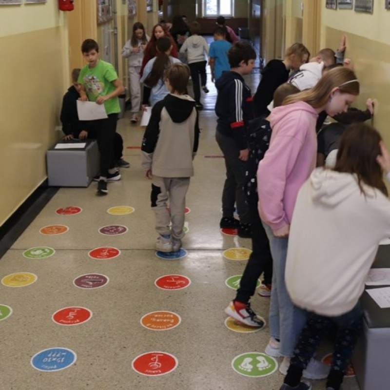 Uczniowie klasy 5 w trakcie wykonywania zadań w grupach i przechodzenia pomiędzy stacjami