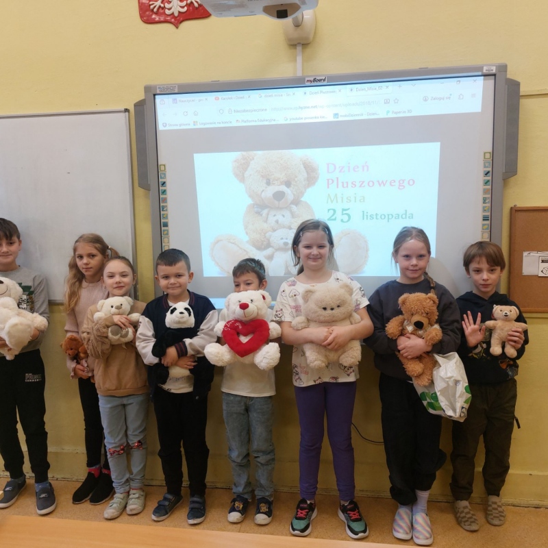 Uczniowie klasy 2b z misiami na tle napisu