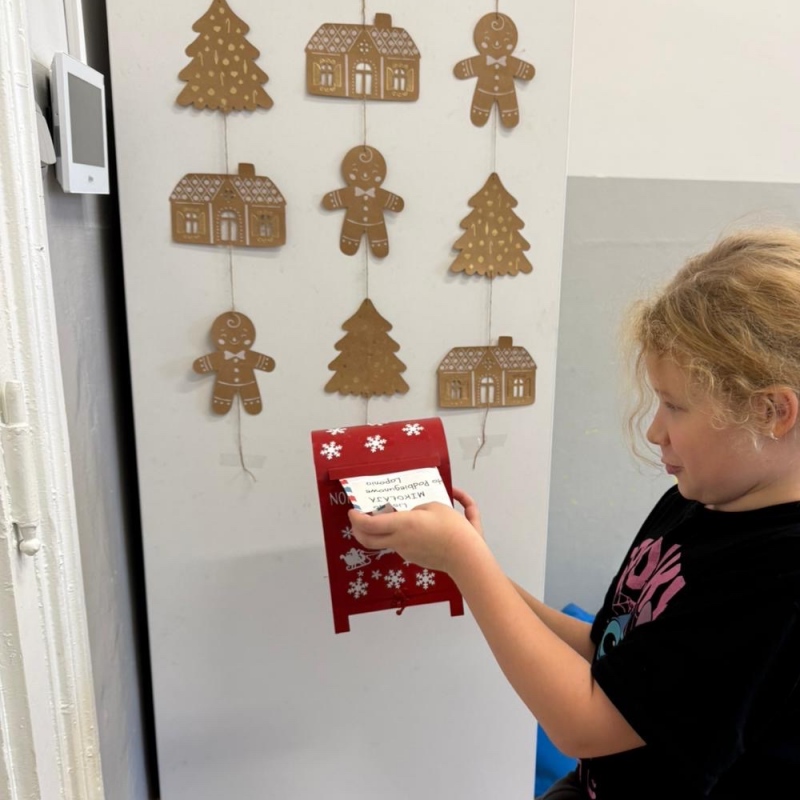 Uczeń wrzuca list do skrzynki świetlicowej listów do świętego Mikołaja