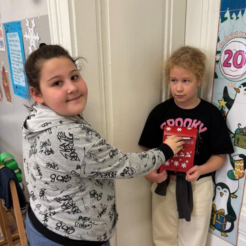 Uczennica wrzuca list do skrzynki świetlicowej druga uczennica trzyma skrzynkę