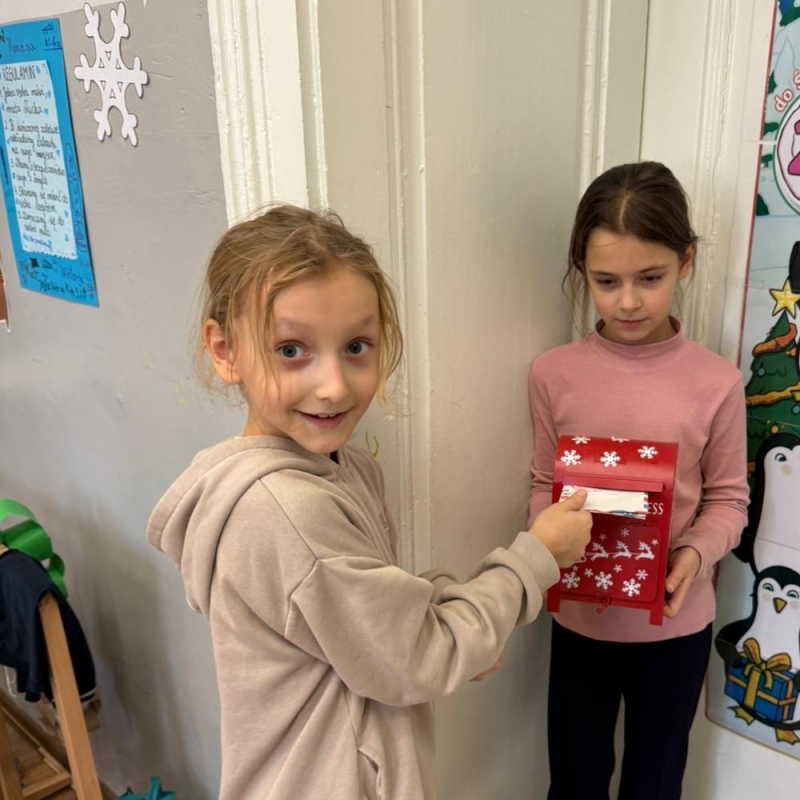 Uczennica wrzuca list do skrzynki świetlicowej druga uczennica trzyma skrzynkę