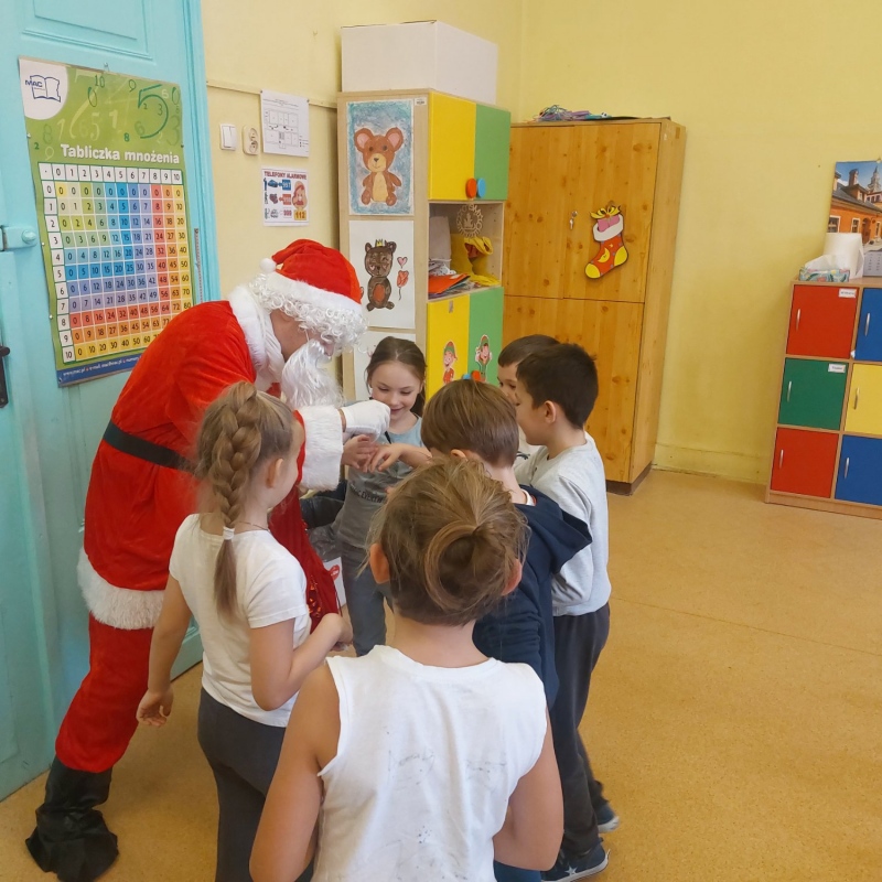 Dzieci z Mikołajem, który rozdaje podarki