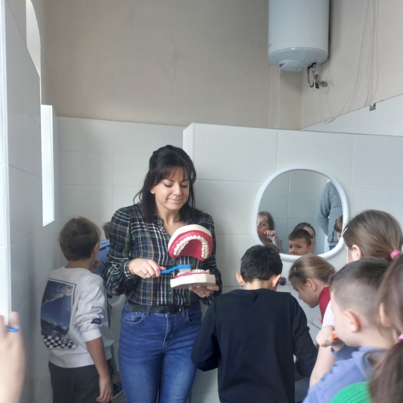 Nauczycielka z uczniami podczas mycia zębów