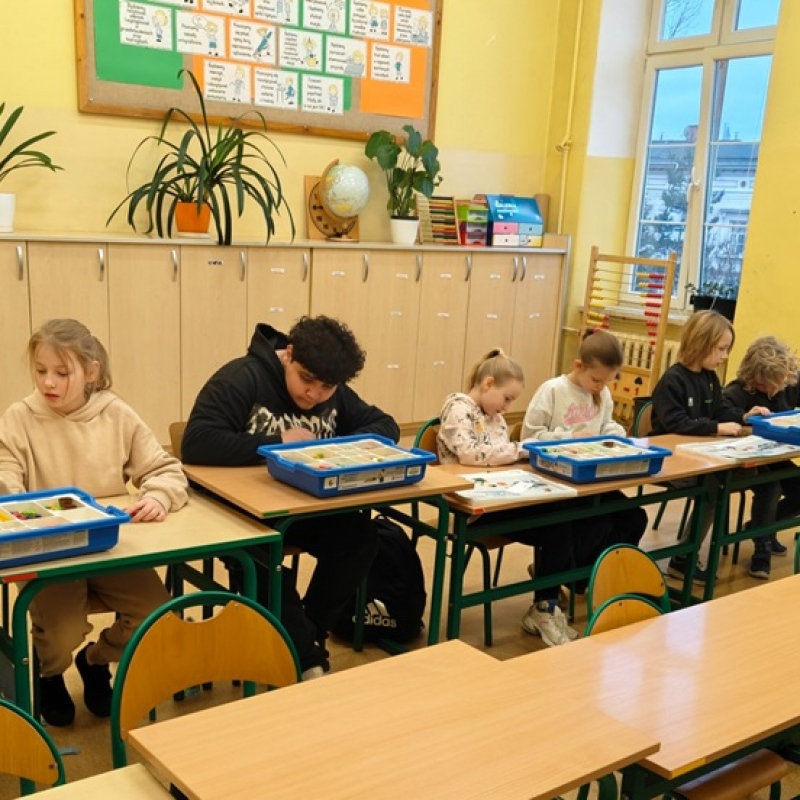 uczniowie budują z klocków lego