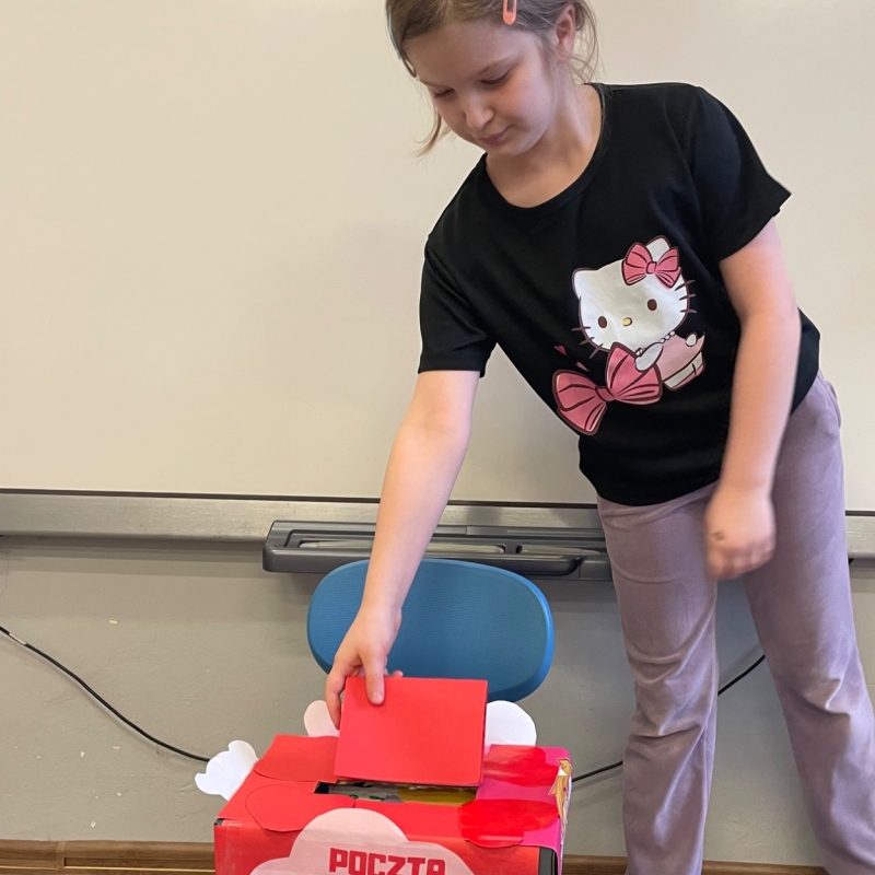 Uczennica wrzucający kartkę do świetlicowej skrzynki