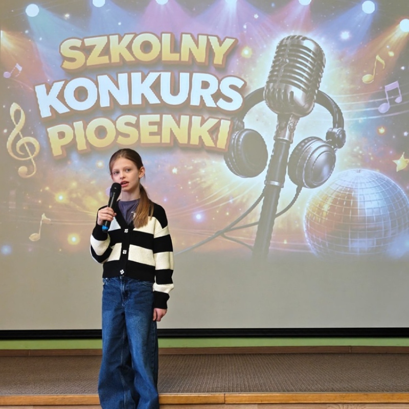 dziecko śpiewające na tle baneru szkolny konkurs piosenki