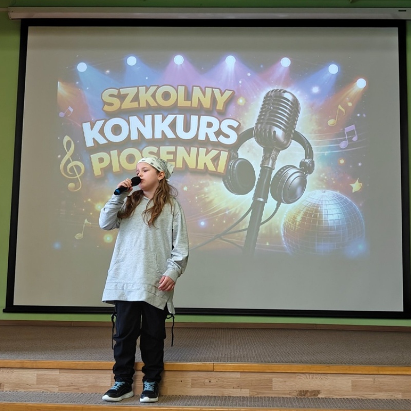 dziecko śpiewające na tle baneru szkolny konkurs piosenki