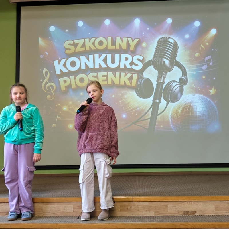 dziecko śpiewające na tle baneru szkolny konkurs piosenki
