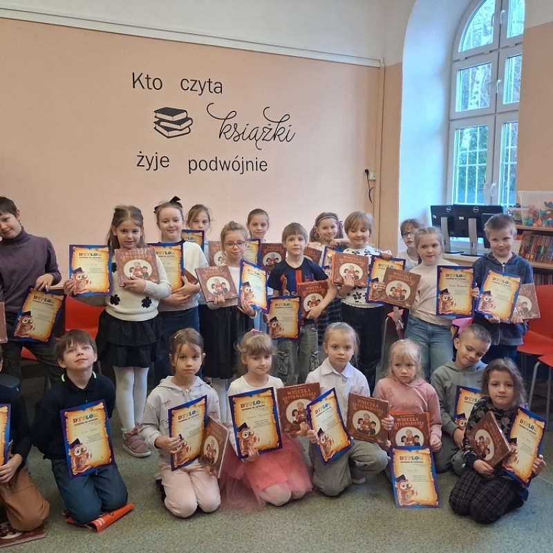 uczniowie w bibliotece pozują z dyplomami czytelnika