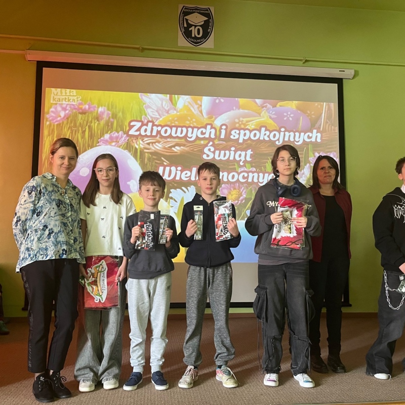 zwyciscy uczniowie na scenie z dyplomami