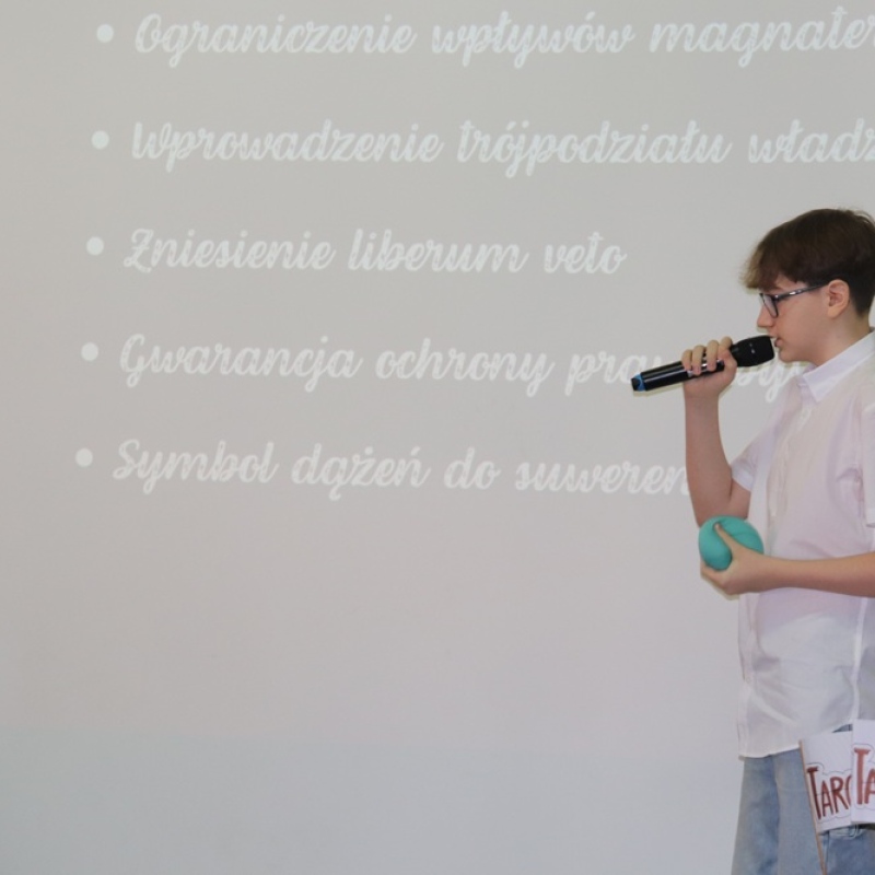 uczeń na tle slajdu z wymienionymi skutkami konstytucji 3 Maja