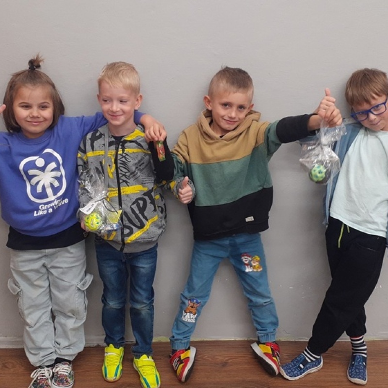 chłopcy stoją obok siebie z upominkami