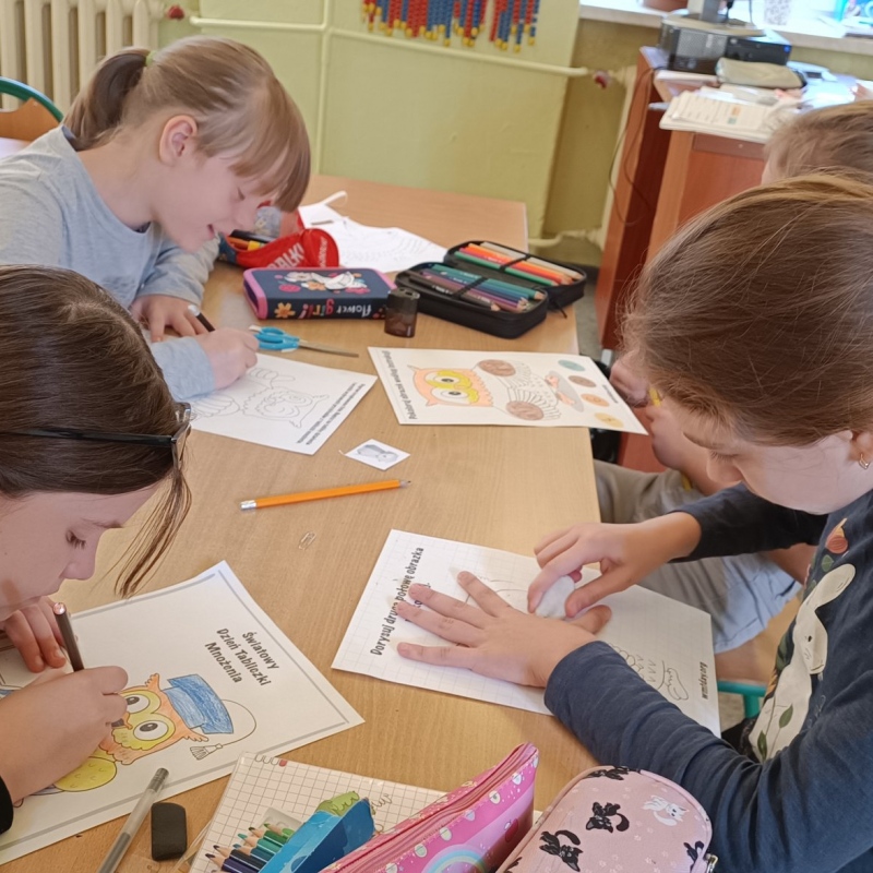 Uczniowie klasy 3 tworzący kolorowanki z sową z okazji DTM