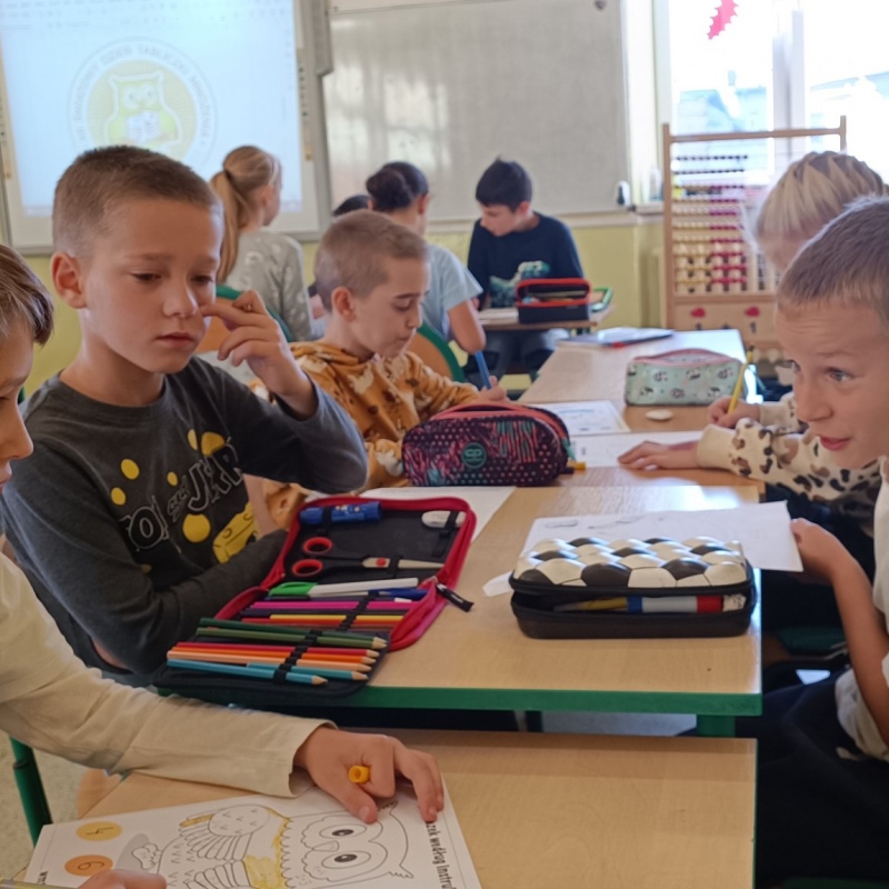Uczniowie klasy 3 tworzący kolorowanki z sową z okazji DTM