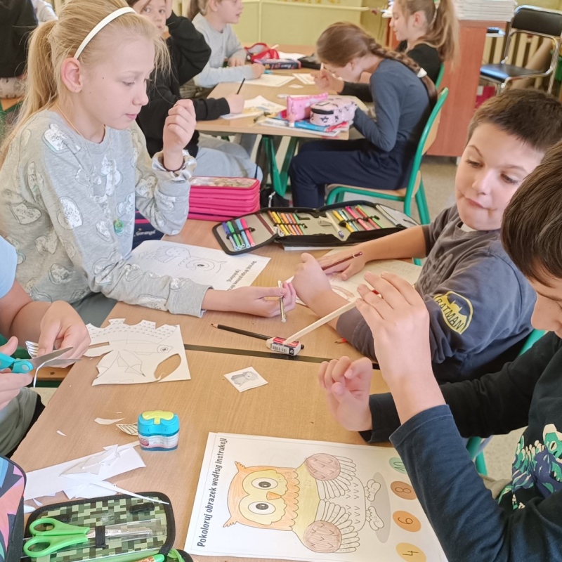 Uczniowie klasy 3 tworzący kolorowanki z sową z okazji DTM