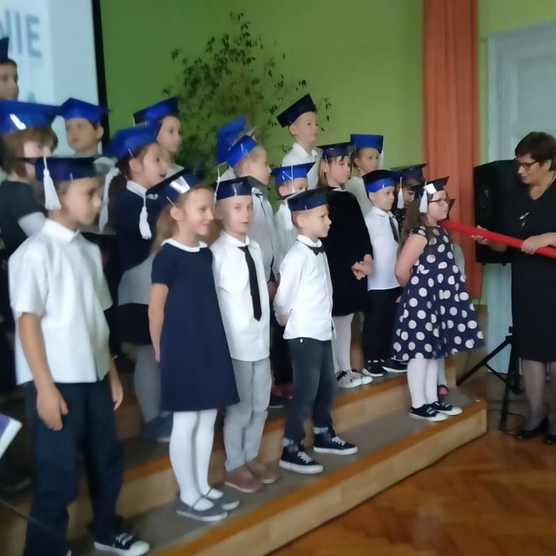 Pani Dyrektor dokonuje aktu Pasowania na ucznia wielkim czerwonym ołówkiem