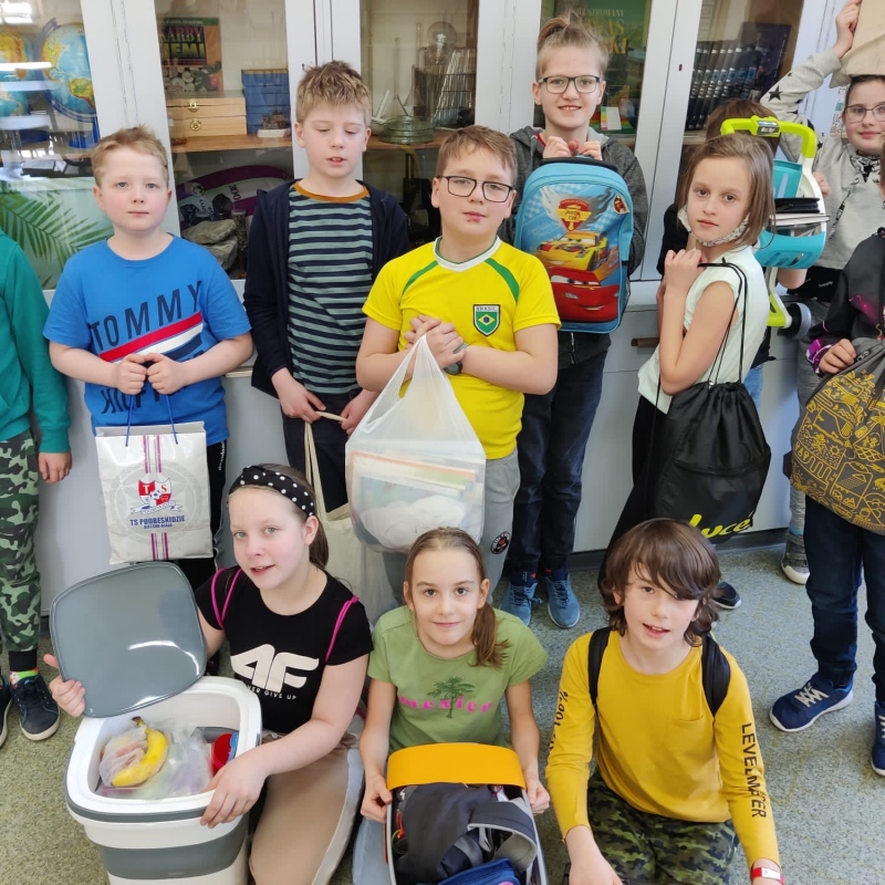 zdjecie:Uczniowie klasy 4 z przedmiotami, w których przynieśli przybory szkolne zamiast plecaków